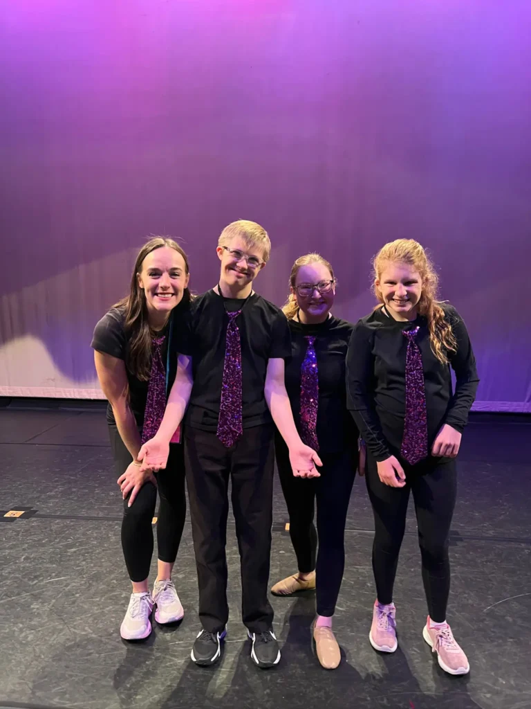 four-people-posing-on-stage